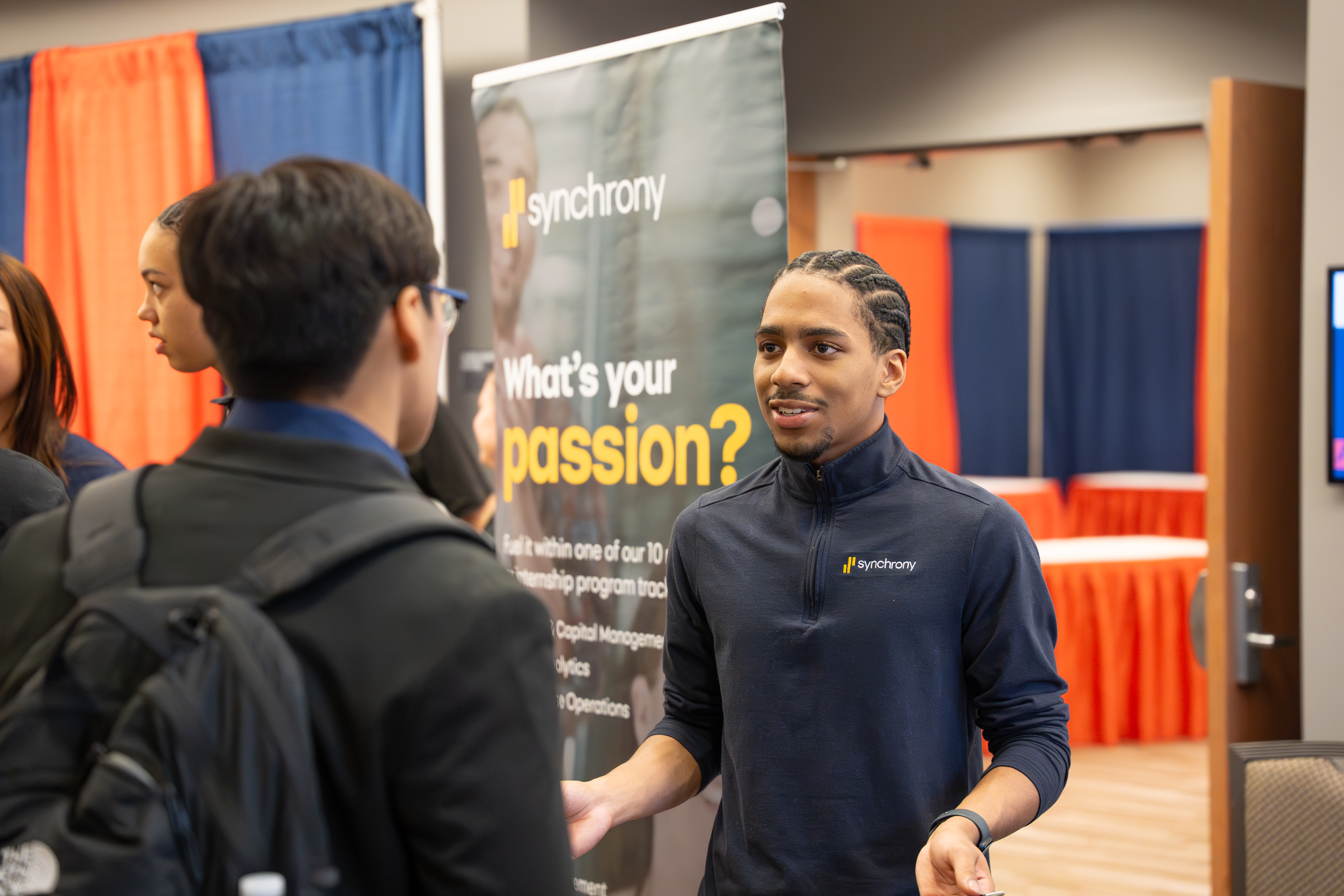 Synchrony Employee talking with student at job fair.
